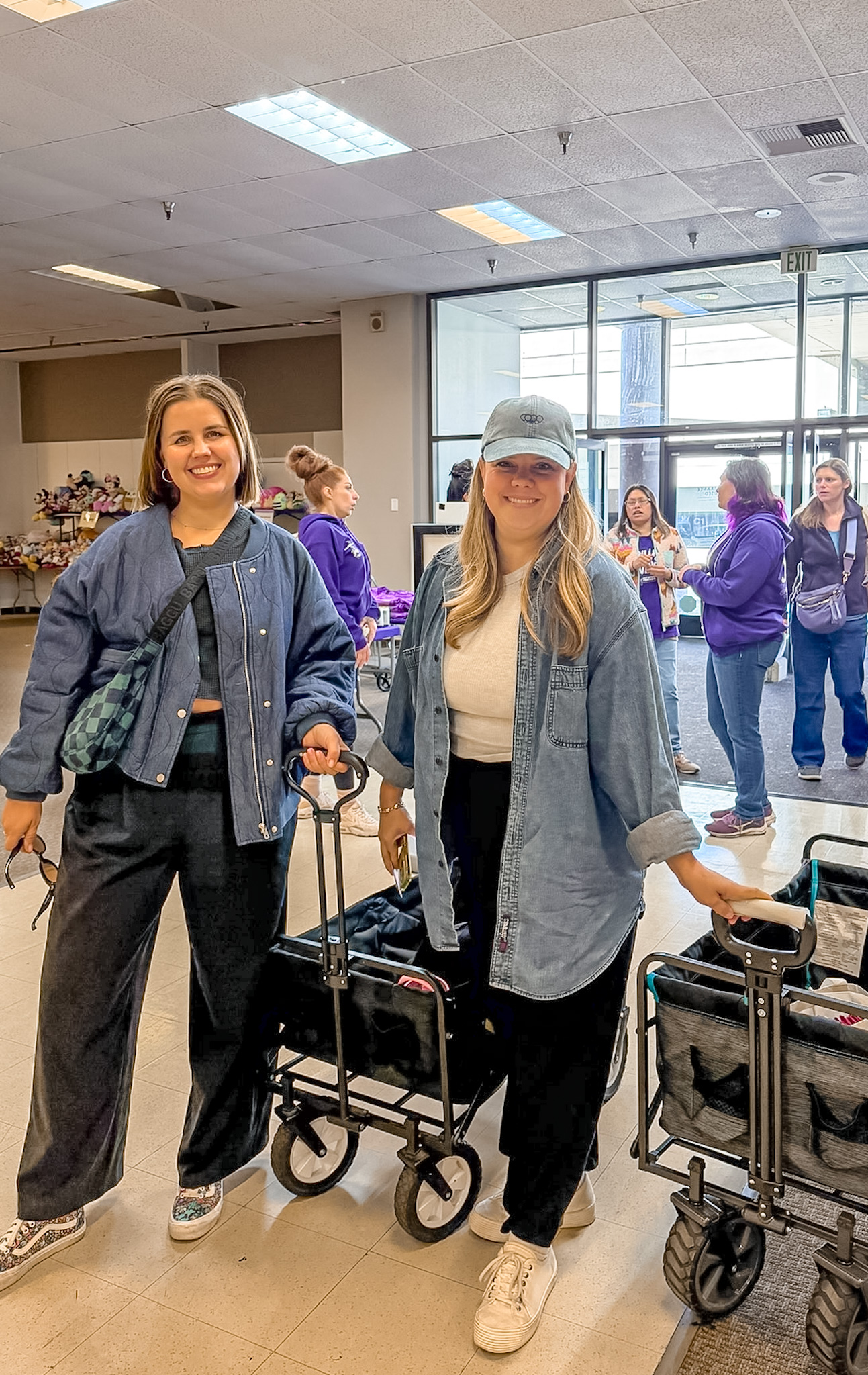 Two women coming in with their wagons to shop and they have big smiles.