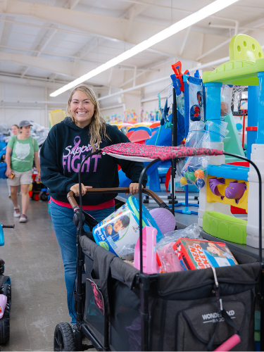 Mom with monderwagon full of toys at the JBF Harrington sale