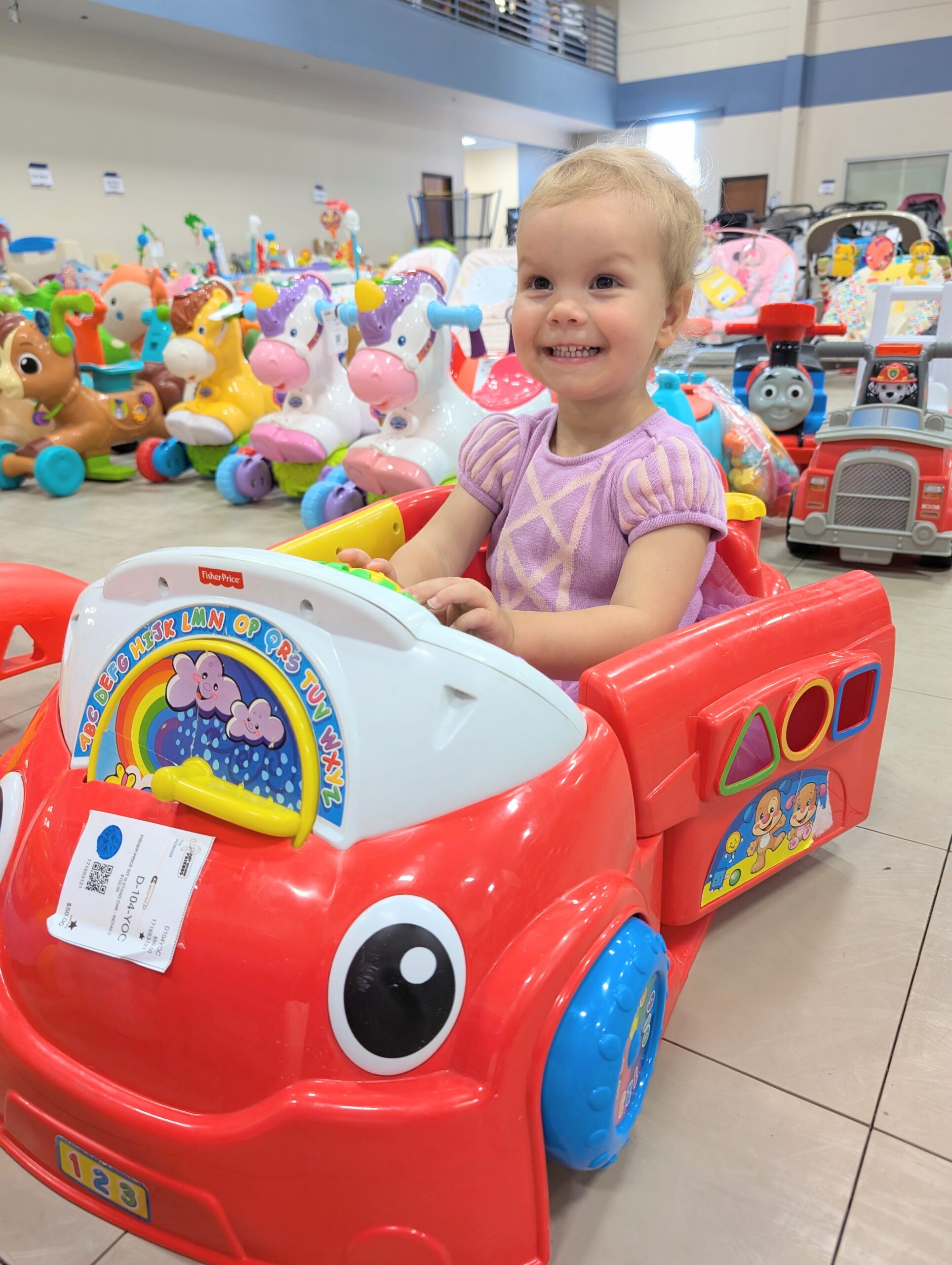 Happy child in red toy car