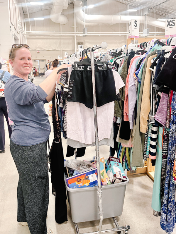 Mom using clothing rolling rack to drop off clothing at the JBF Harrington Children's consignment sale