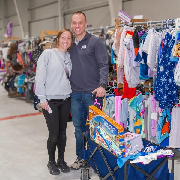 smiling man and woman with a wagon full of items at the sale
