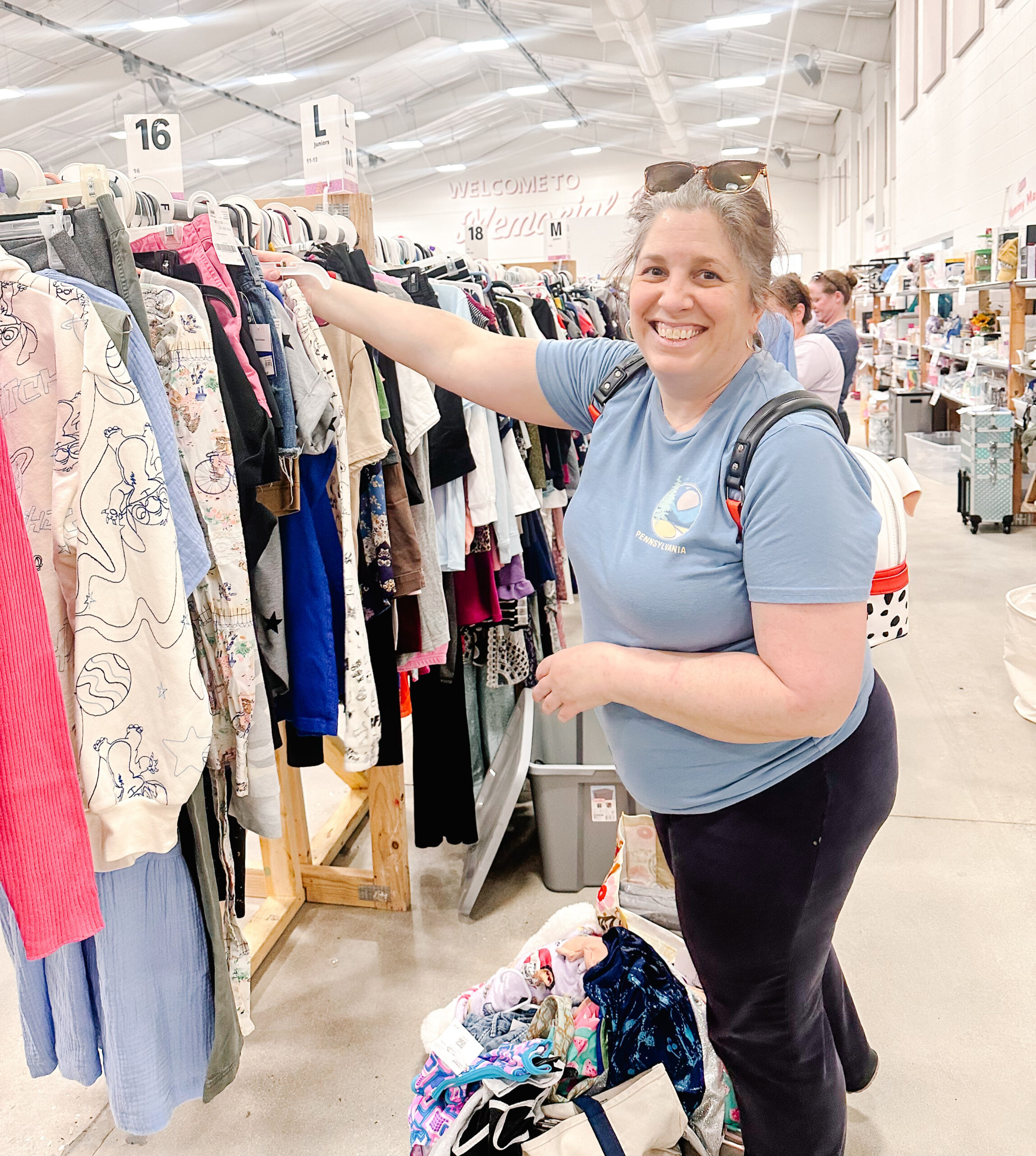 Mom organizing children’s clothing at a resale event
