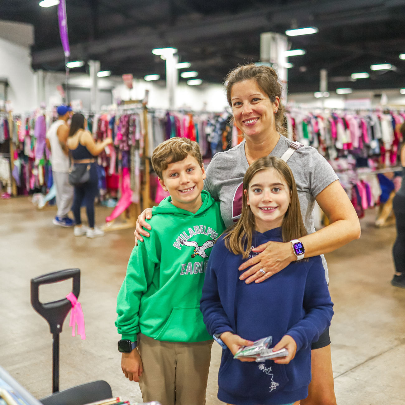 woman and her two kids smiling at a sale