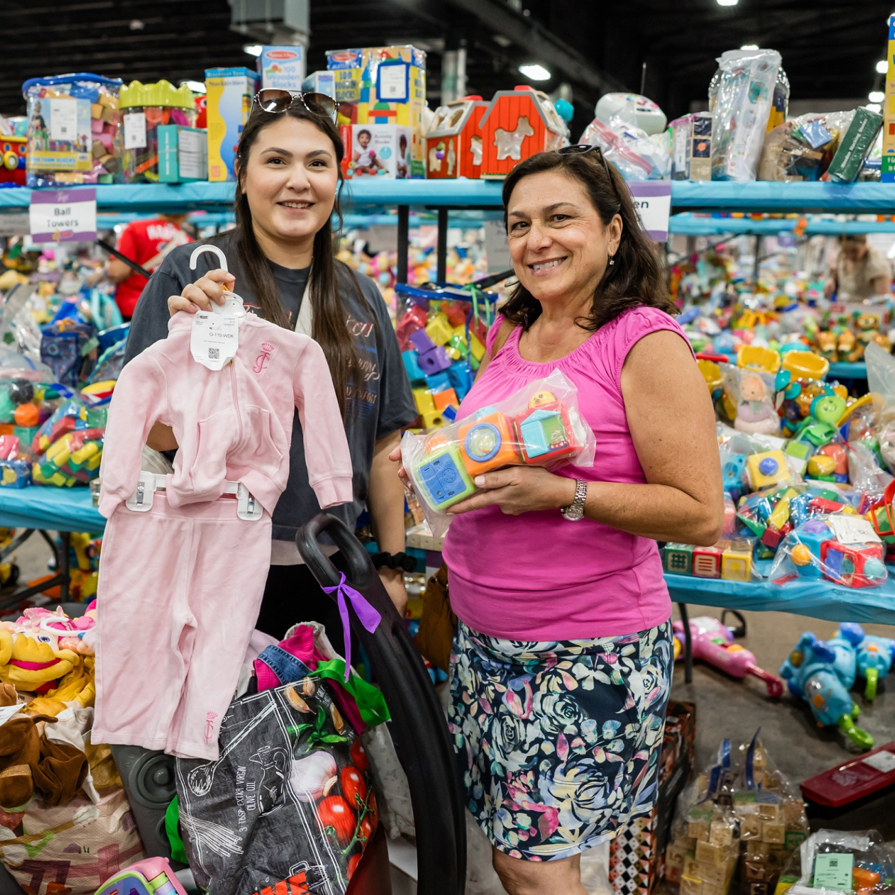 two smiling women holding toys